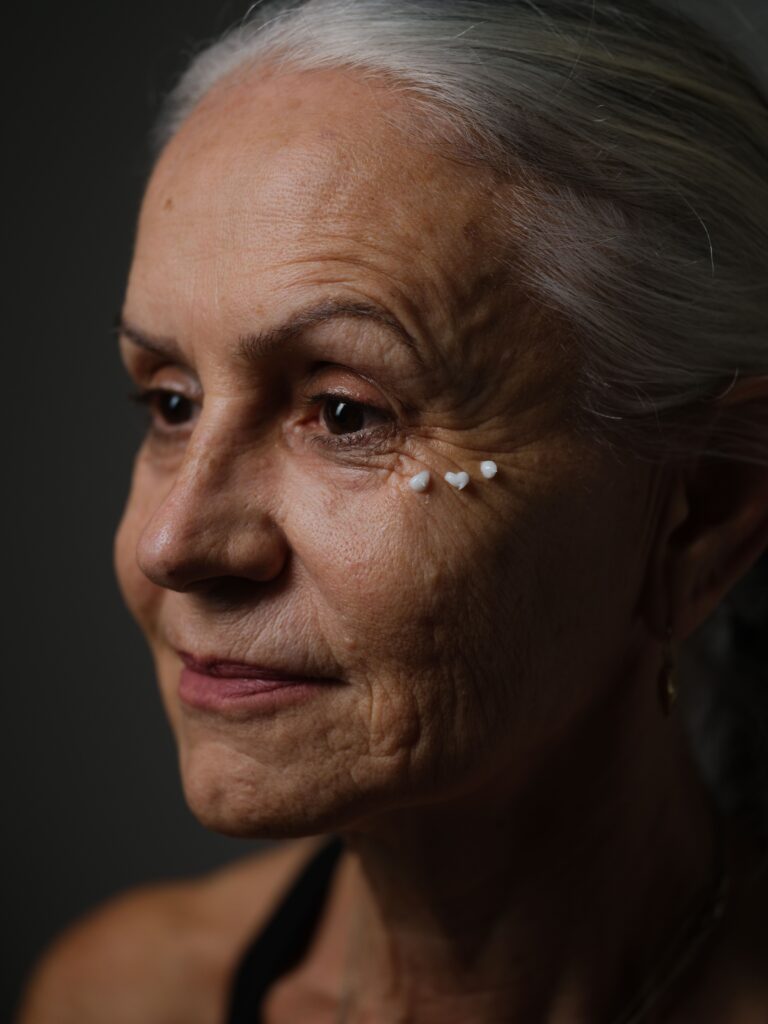 Artistic portrait featuring a senior woman with visible skincare elements. Captures aging gracefully.